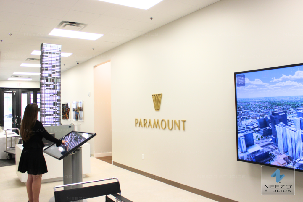 Interactive real estate sales platform LiveSite® used on a touchscreen in a sales gallery, integrated with a physical scale model
