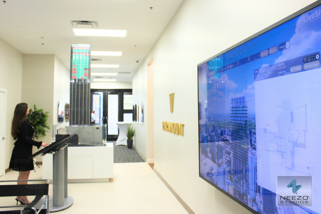 Interactive real estate sales platform LiveSite® used on a touchscreen in a sales gallery, integrated with a physical scale model by NEEZO Studios for luxury sales gallery